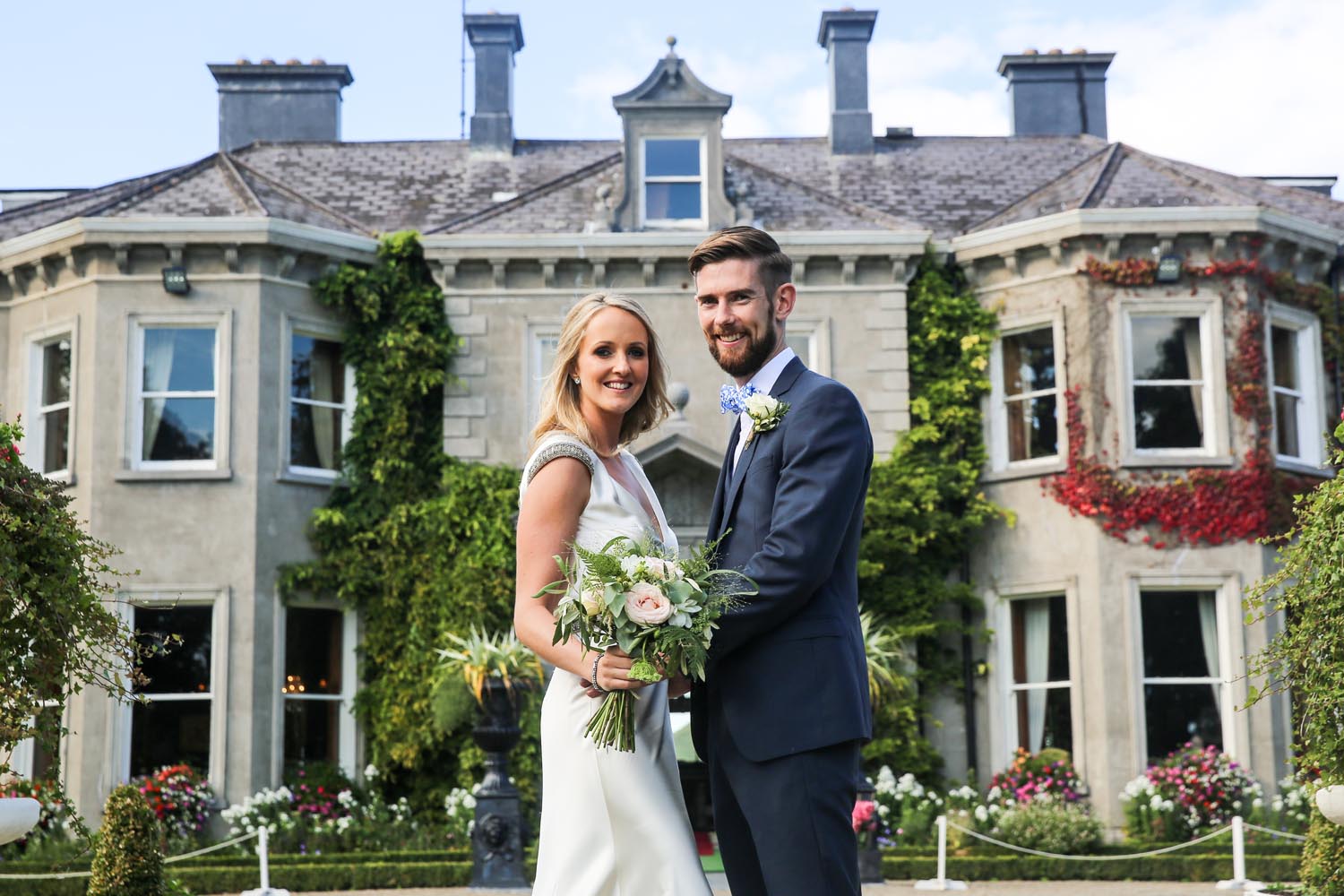 Married couple embracing in front of Tinakilly House, Co. Wicklow