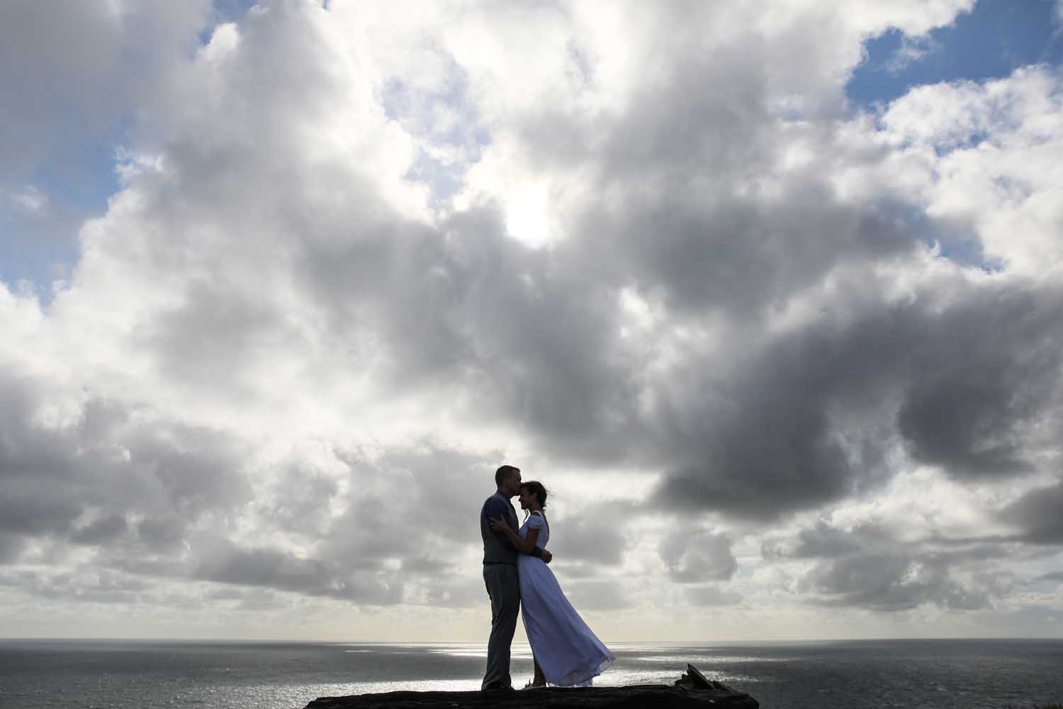 Couple embrace on the cliff's edge during their elopement at the Cliffs of Moher