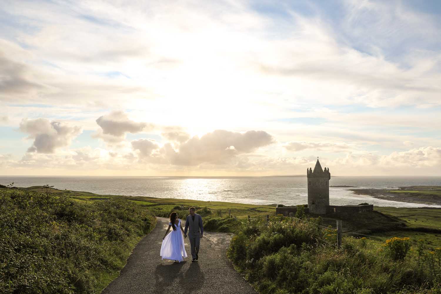 Married couple walking by Doonagore Castle, Co. Clare, Ireland