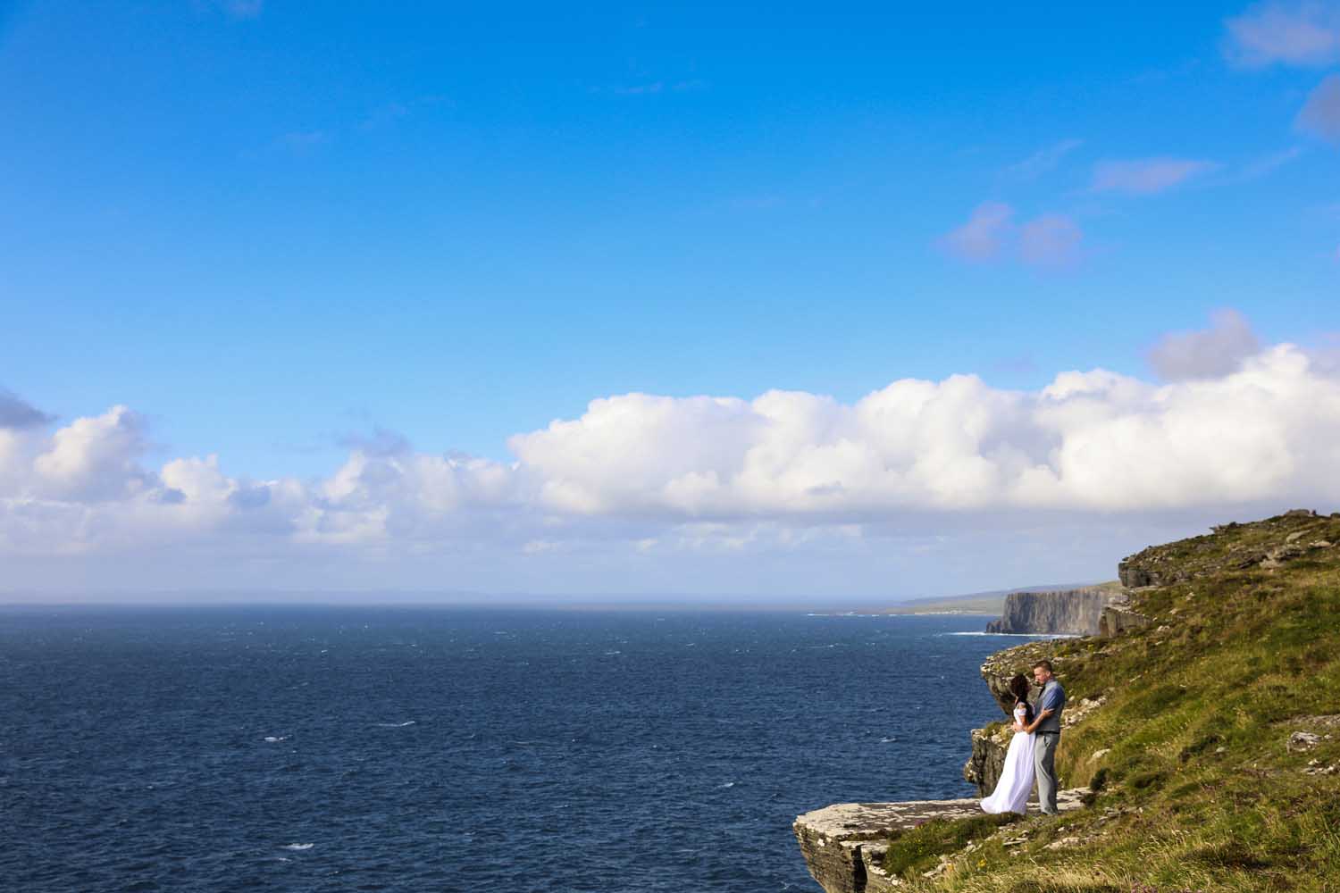Married couple standing at the edge of a cliff, Co. Clare, Ireland