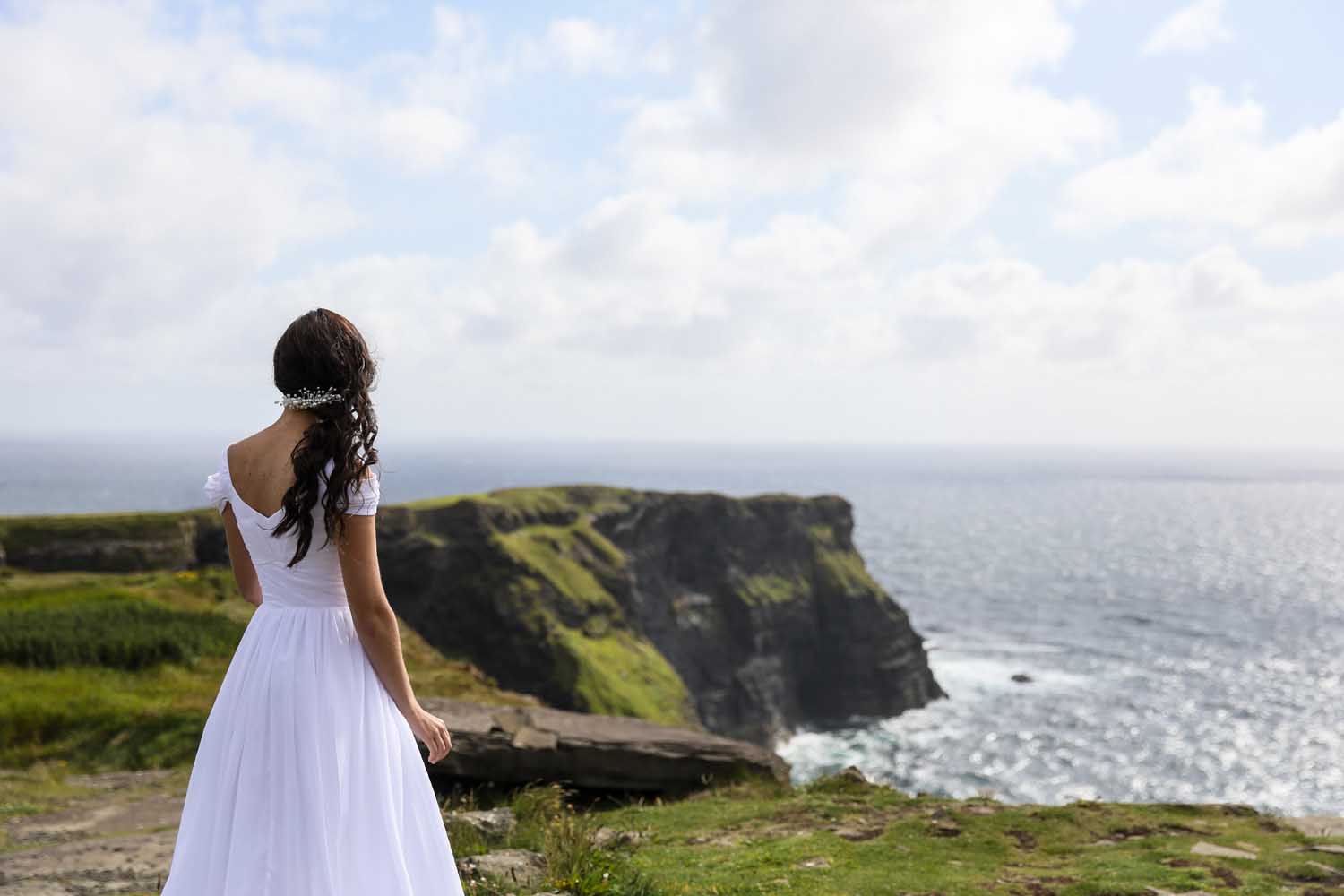 Bride looks out at the Atlantic Ocean on her wedding day