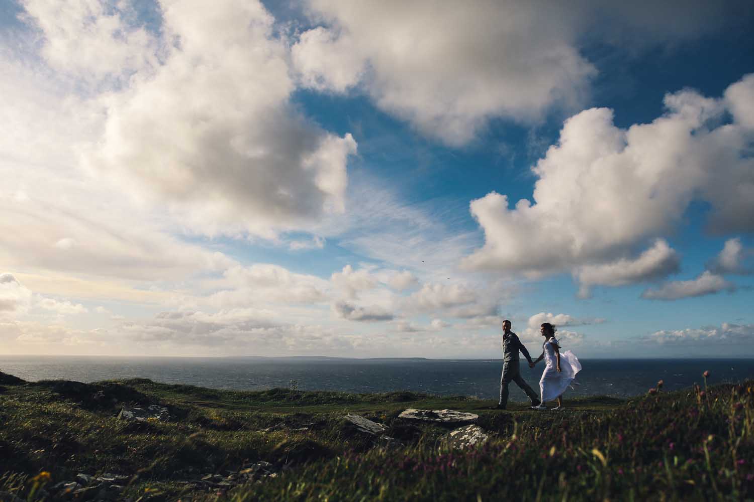 Married couple walking along the coastline in Co. Clare, Ireland