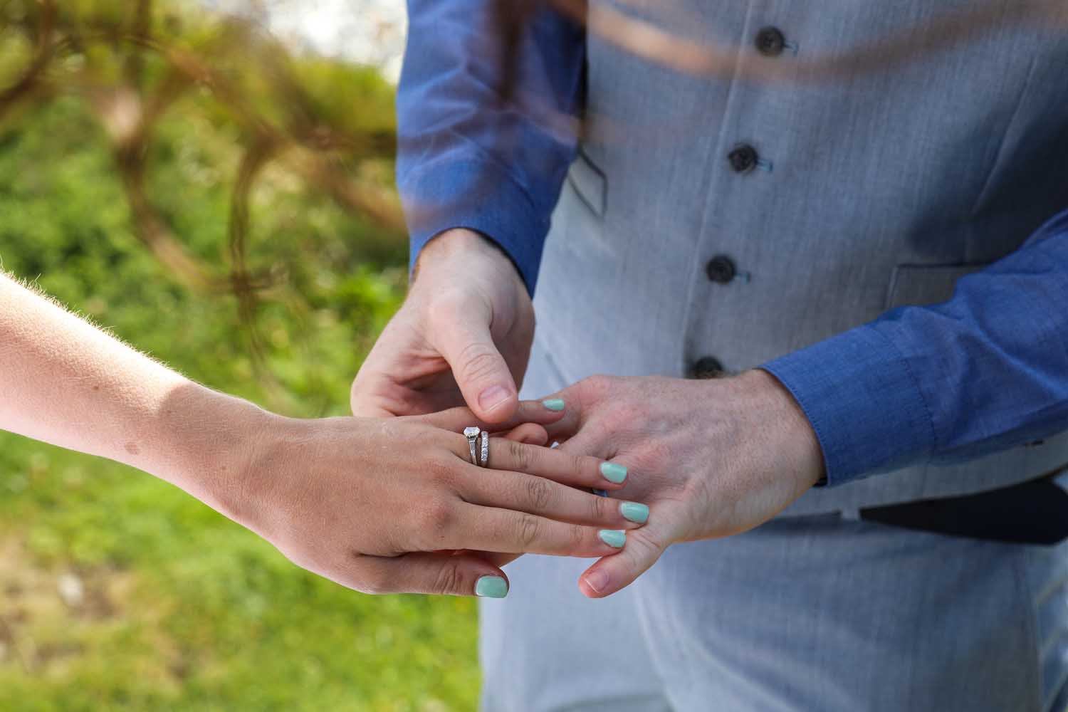 Groom placing a ring on his bride
