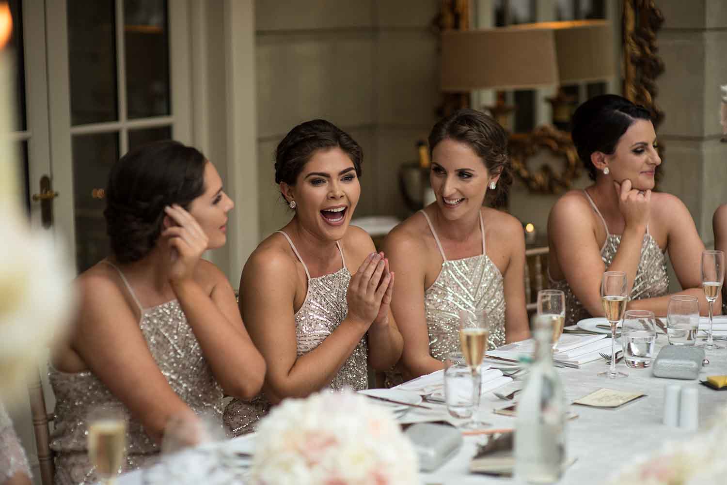 Bridesmaids laughing during wedding speeches