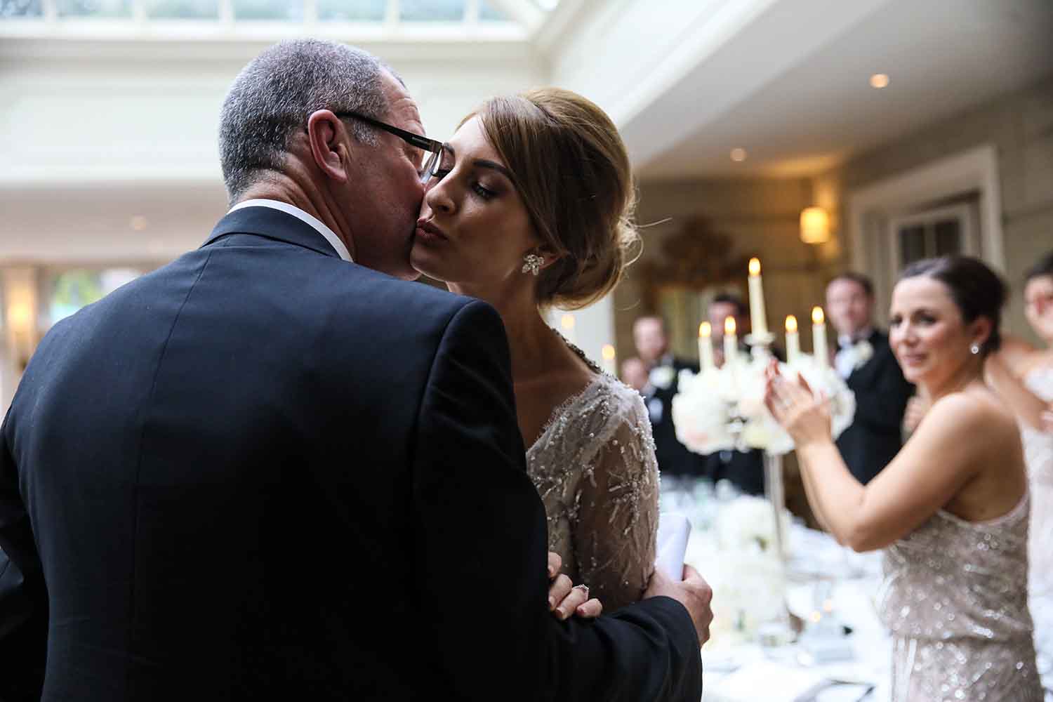 Father and daughter kissing on her wedding day