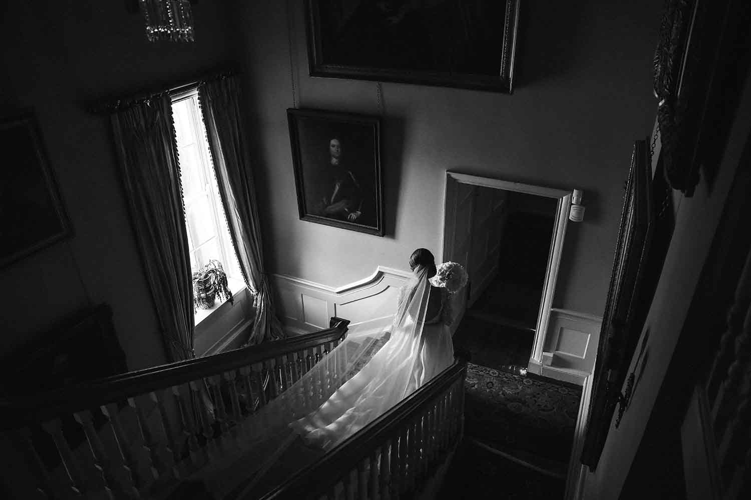 Bride at the bottom of a staircase at Tankardstown House