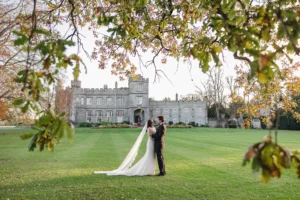 Married couple kissing on the lawn with Luttrellstown Castle in the background